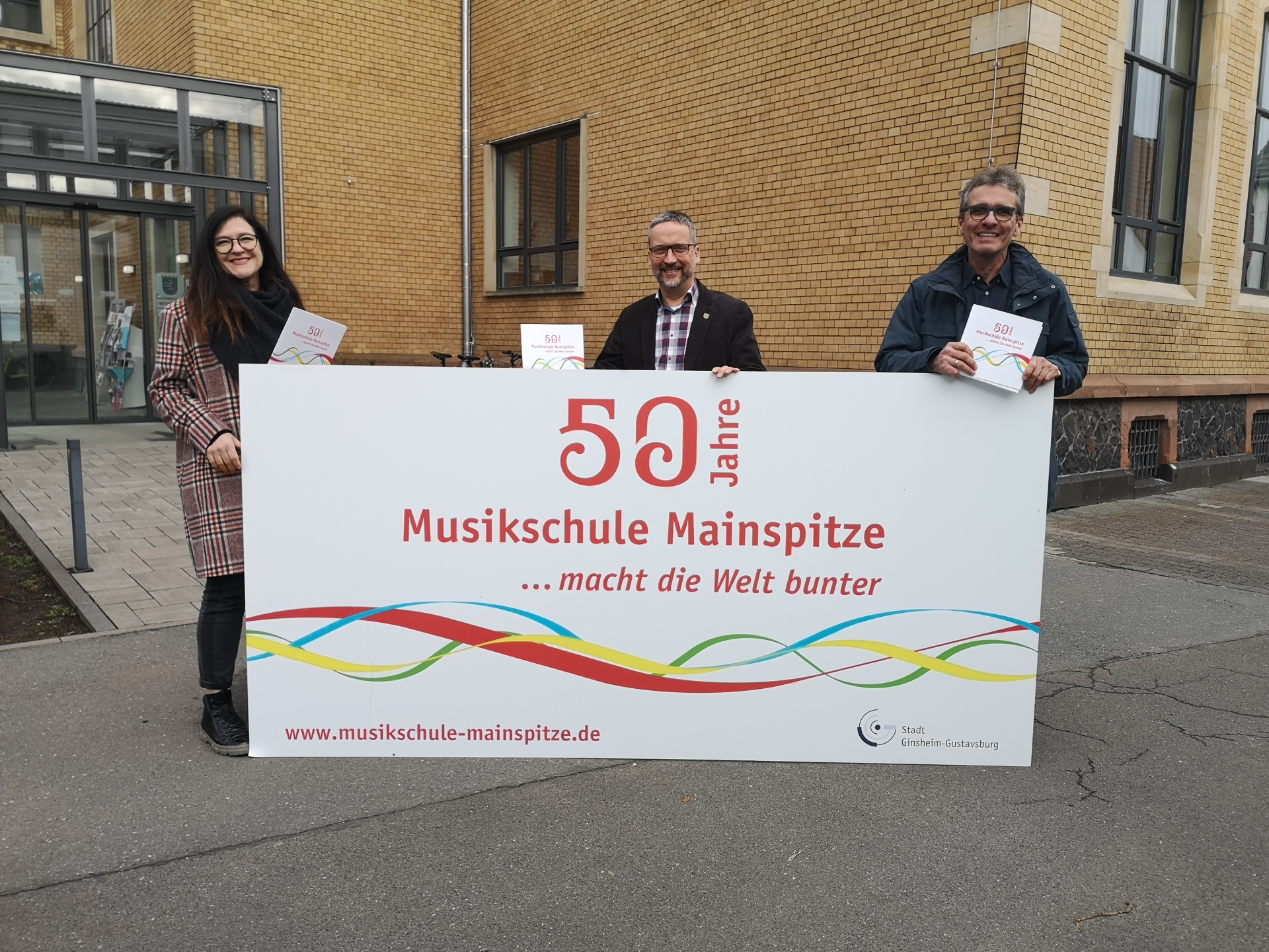 Rathausmitarbeiter, Bürgermeister und Werbebanner "50 Jahre Musikschule Mainspitze" Banner: 50 Jahre Musikschule Mainspitze