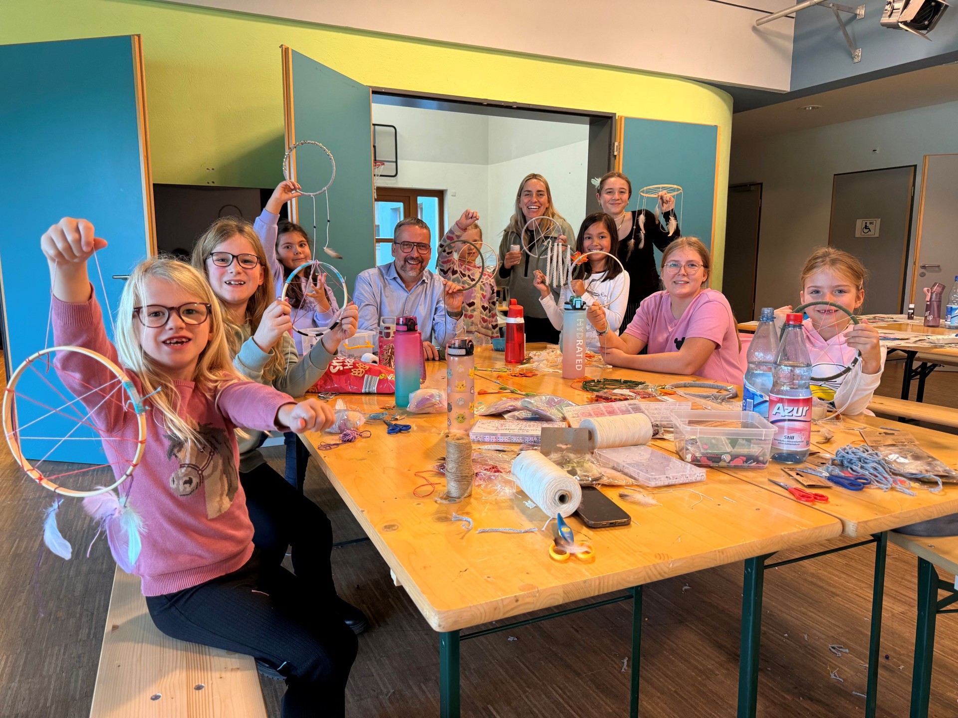 Bürgermeister Thorsten Siehr bastelt mit den Ferienspielkindern Traumfänger