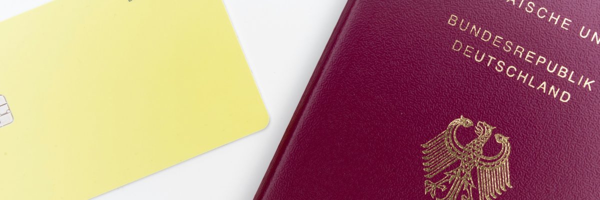 Ein deutscher Reisepass und eine Bankkarte liegen auf einem weißen Tisch